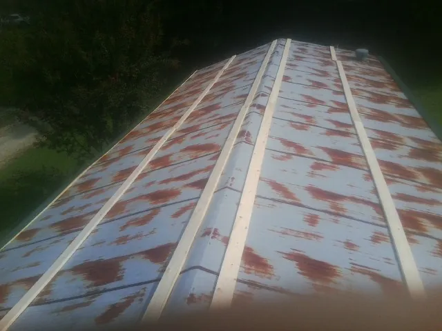 Rusted metal roof panels with new wood purlins before replacement — Storm Damage Roof Repair in Girdletree by Roofing Brothers