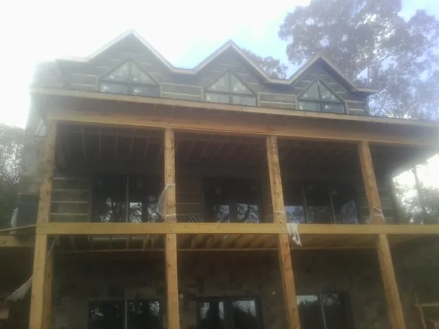 Dormers and porch framing on a large log home under construction — Roof Coating work by our crew in Girdletree